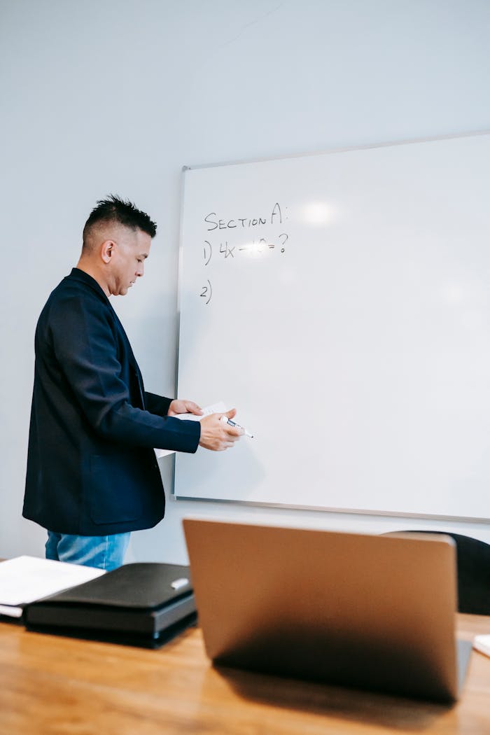 Educator discussing concepts during a lesson with notes on a whiteboard.
